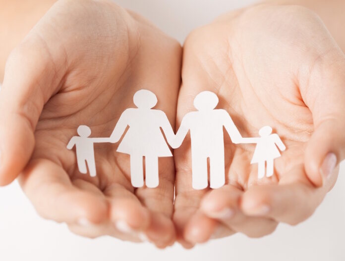womans hands with paper man family