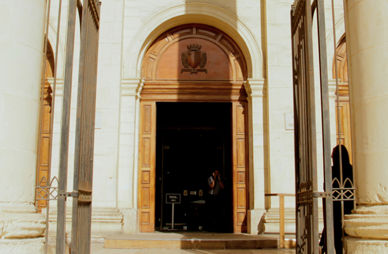 Raġel mixli li ta n-nar pjanta ma’ bieb ta’ dar