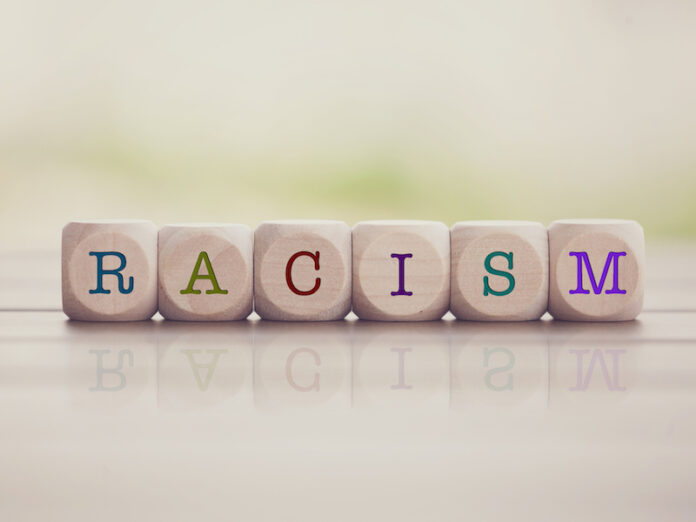 Racism word written on cube wooden blocks.