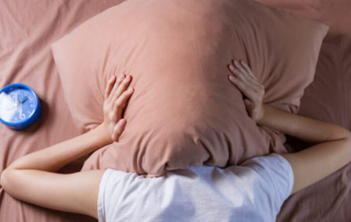 woman cover her head with pillow