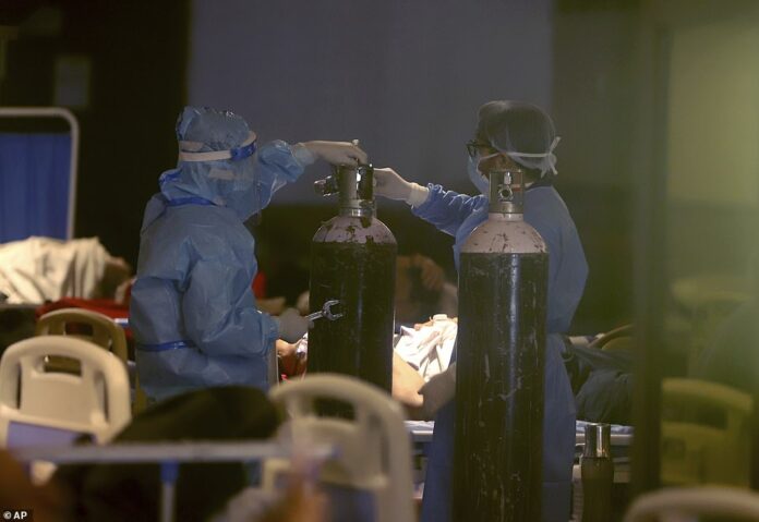 42420324-9529923-Health_workers_install_oxygen_cylinders_for_COVID_19_patients_at-a-41_1619797736836
