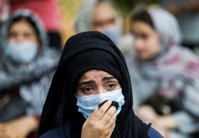 An Afghan national reacts at a gathering to urge the international community to help Afghan refugees, in New Delhi