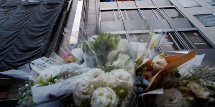 FILE PHOTO: Flowers are placed by the building where a fire broke out, in Osaka