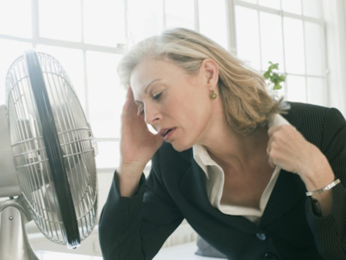 Hot businesswoman sitting in front of fan