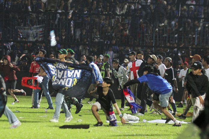 Arema FC supporters enter the field after the team they support lost to Persebaya after the league BRI Liga 1 football match in Malang