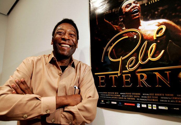 FILE PHOTO: Brazilian soccer legend Pele poses next to a poster for the documentary film "Pele Forever" at New ...