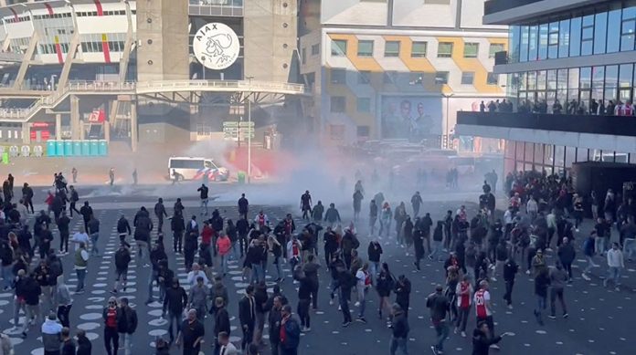 Police officers use teargas to disperse football fans rioting Johan Cruijff Arena