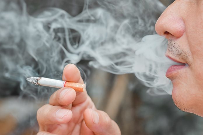 Man smoking cigarette with many smoke,when a cigarette is burning, they create more chemicals. These nicotine, tar, and carbon monoxide, formaldehyde, ammonia, hydrogen cyanide, arsenic and DDT