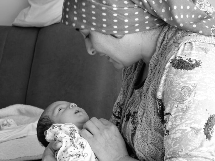 close-up-mother-holding-baby-son-home