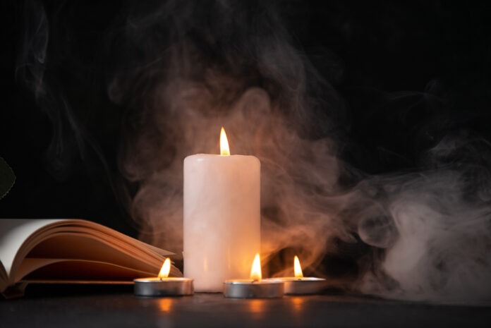 front view of burning candle on dark surface funeral war death e