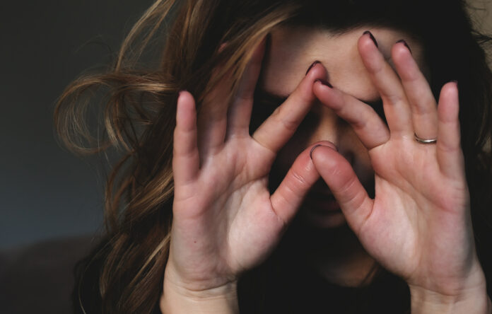 Upset woman covers her face with her hands. Depression